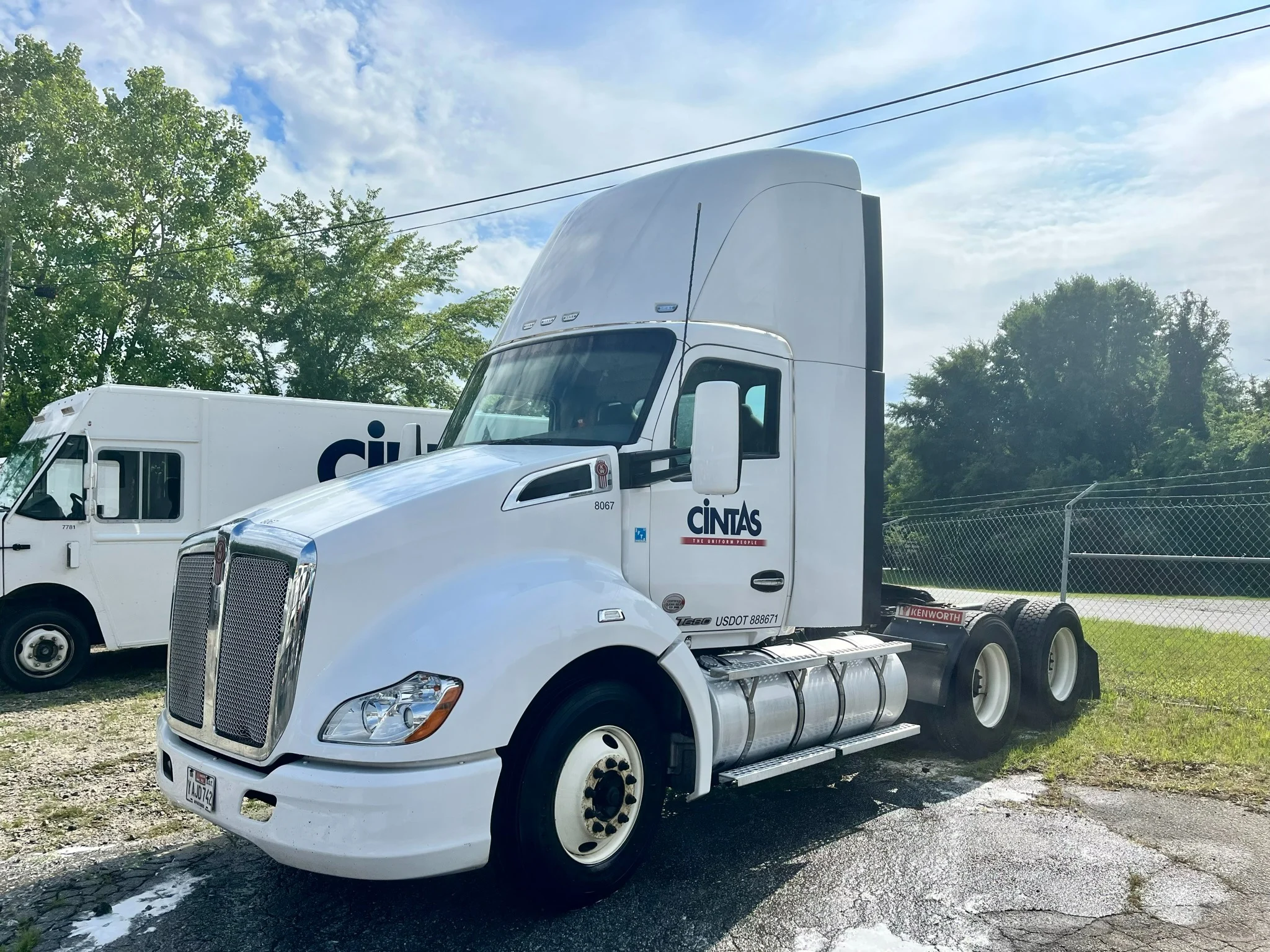 Same white semi truck after exterior cleaning, photographed from the driver side