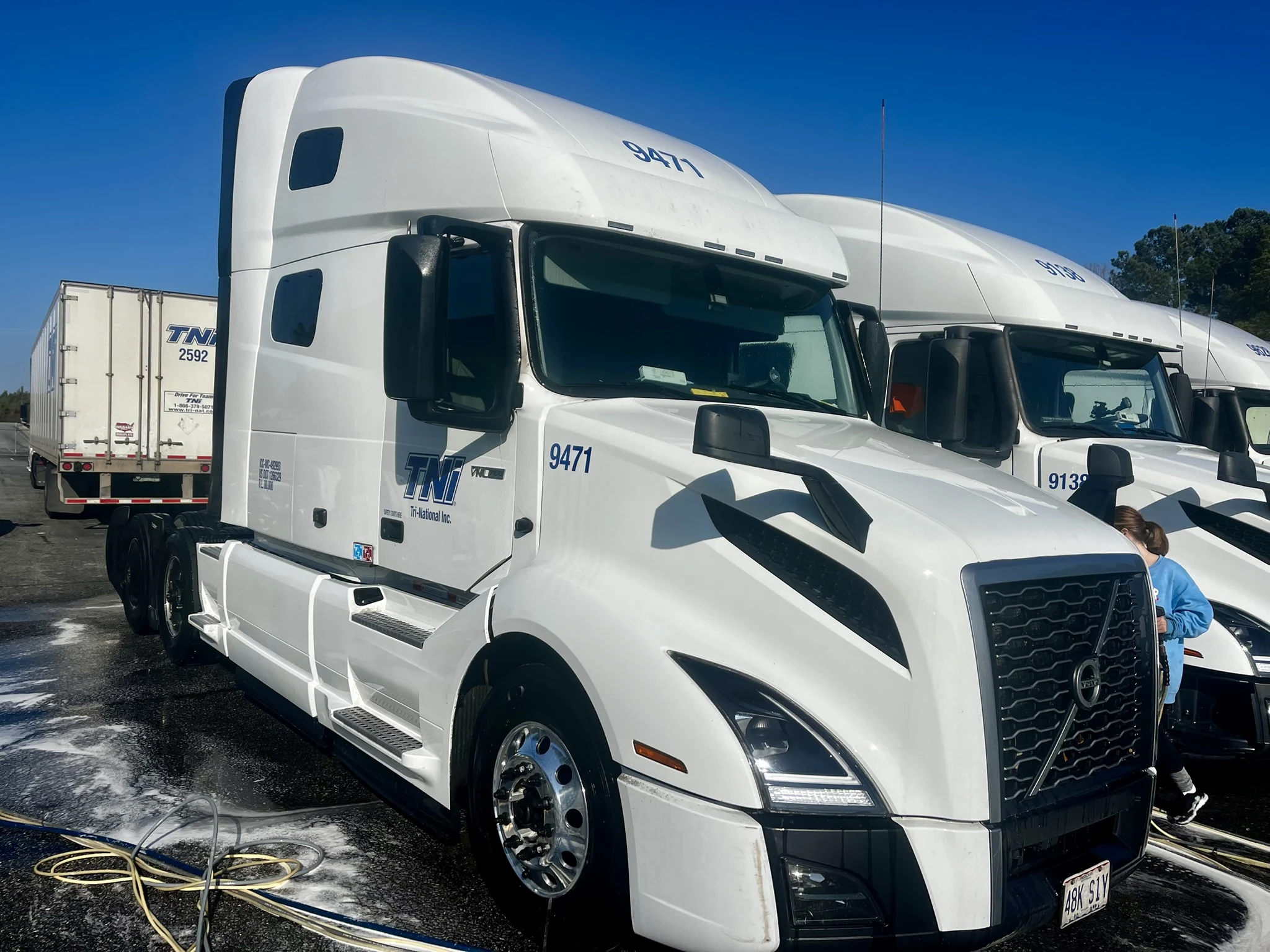 White fleet tractor after washing, with visibly cleaner steps and side panels